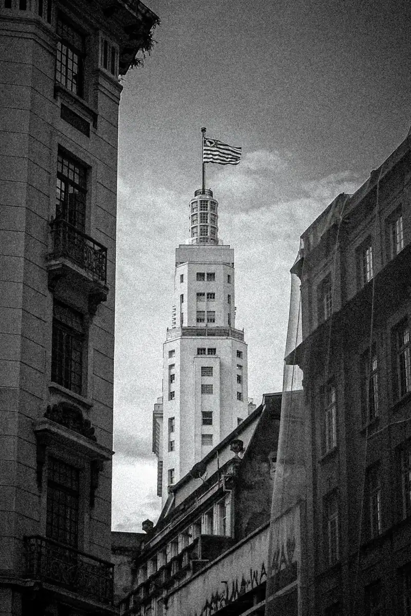 Edifício Altino Arantes entre prédios históricos do centro de São Paulo, em preto e branco, com granulação